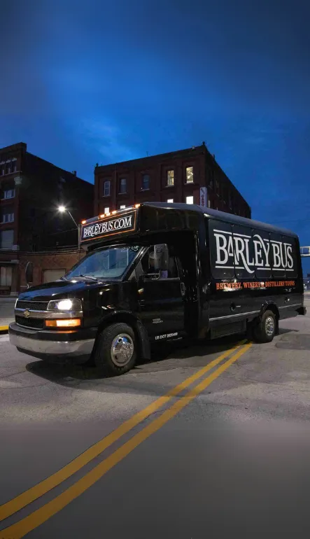 Barley Bus party bus parked on a Kansas City street at night